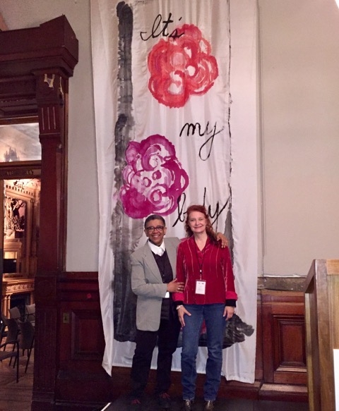 Sheril Antonio and Karen Finley in front of the hand painted banners hung in the armory.